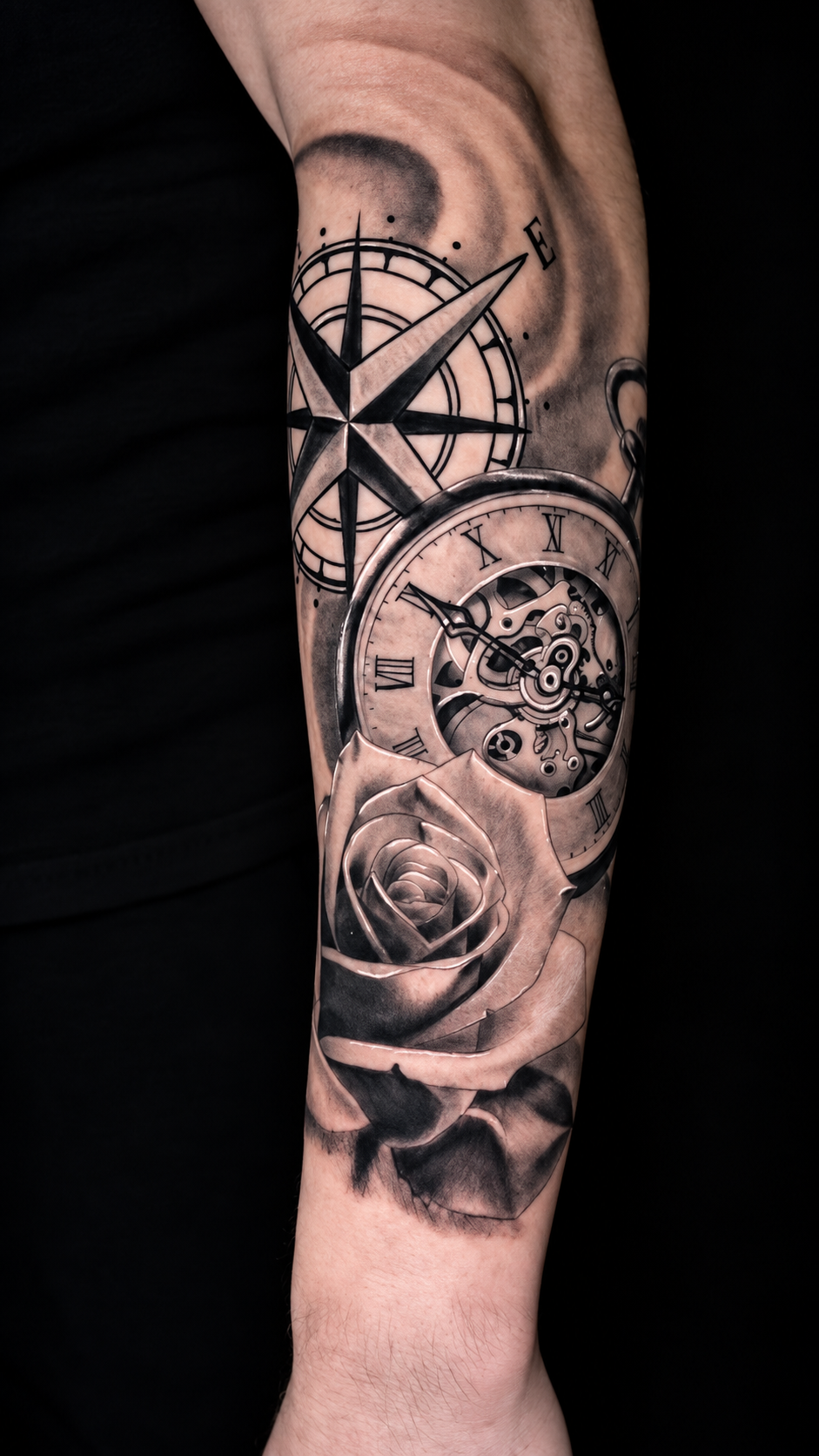 Tatuagem de bússola, relógio e rosa no antebraço